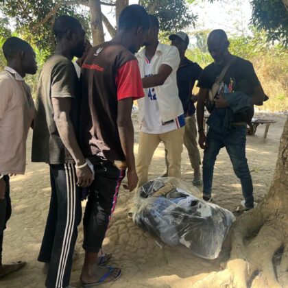 Groupe rassemblé autour de sacs de vêtements